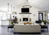 Thumbnail 30 of 40 - a living room with a fireplace and a kitchen in the backgroundat Addison on Cobblestone, Fayetteville, 30215