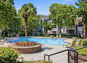 Thumbnail 25 of 42 - Swimming pool surrounded by landscaping and lounge seating at Alden Place at South Square Apartments, North Carolina, 27707