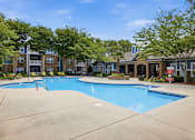 Thumbnail 32 of 42 - Resort style pool with clubhouse and surrounding trees at Alden Place at South Square Apartments, Durham, NC