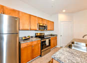 Thumbnail 17 of 42 - Modern kitchen with stainless steel appliances and granite countertops at Alden Place at South Square Apartments, Durham, North Carolina