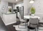 Thumbnail 5 of 40 - a dining room with a table and chairs and a kitchen with a refrigerator at Ansley at Town Center, Evans, Georgia