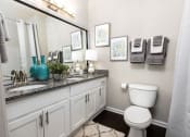 Thumbnail 13 of 40 - a bathroom with a toilet and a sink and a mirror at Ansley at Town Center in Evans GA
