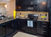 Thumbnail 22 of 40 - a kitchen with black cabinets and stainless steel appliances at Ansley at Town Center, Evans, Georgia