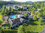 Thumbnail 10 of 30 - A large house with a pool in the middle of a grassy area.