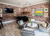 Thumbnail 2 of 30 - A living room with a brick wall and a fireplace.