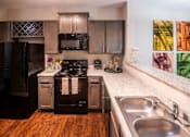 Thumbnail 12 of 30 - A kitchen with a black refrigerator and stove.