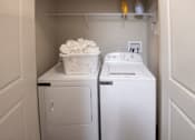 Thumbnail 22 of 30 - A small laundry room with a washer and dryer.