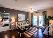 Thumbnail 27 of 30 - A living room with a black and white striped rug and a black chair.