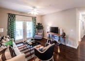 Thumbnail 24 of 30 - A living room with a striped rug and a black and white chair.