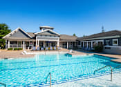 Thumbnail 21 of 30 - A large swimming pool in front of a building with a white roof.