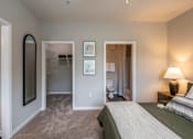 Thumbnail 5 of 26 - A bedroom with a bed, dresser, and mirror.