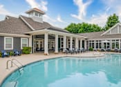 Thumbnail 14 of 26 - A swimming pool is surrounded by a covered patio area.