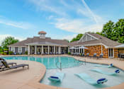 Thumbnail 1 of 26 - A pool with a house in the background.