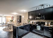 Thumbnail 8 of 26 - A modern kitchen with black cabinets and appliances.