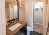 Thumbnail 11 of 26 - A bathroom with a sink, toilet, and shower.