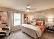 Thumbnail 10 of 26 - A bedroom with a large bed and a ceiling fan.