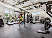 Thumbnail 14 of 18 - A spacious gym with a variety of equipment including treadmills, weights, and a bench press at Arcadia Cartersville Apartments, Georgia