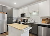 Thumbnail 1 of 18 - A modern kitchen with a wooden countertop and stainless steel appliances. at Arcadia Cartersville Apartments, Georgia, 30121