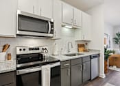 Thumbnail 2 of 18 - A modern kitchen with a black stove top oven and a microwave above it. at Arcadia Cartersville Apartments, Cartersville, GA, 30121