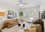 Thumbnail 4 of 18 - A living room with a brown couch, a coffee table, and a ceiling fan. at Arcadia Cartersville Apartments, Cartersville, 30121