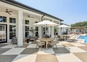 Thumbnail 12 of 18 - A patio with a table and chairs and an umbrella at Arcadia Cartersville Apartments, Cartersville