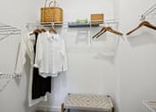 Thumbnail 6 of 18 - A white shirt is hanging on a hanger in a closet at Arcadia Cartersville Apartments, Cartersville, Georgia