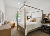 Thumbnail 5 of 18 - A bedroom with a four poster bed and a table with a lamp on it at Arcadia Cartersville Apartments, Georgia