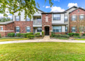 Thumbnail 15 of 18 - front view of an apartment building with green grass and trees at Artesian on Westheimer, Texas