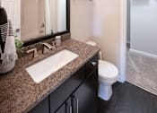 Thumbnail 12 of 27 - A bathroom with a sink, mirror, toilet and a shower at Ansley at Town Center Apartments, Evans, Georgia