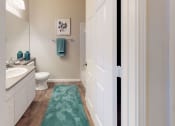 Thumbnail 5 of 36 - a bathroom with a white sink and toilet next to a green rug at Autumn Park Apartments, Charlotte, North Carolina