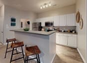 Thumbnail 1 of 36 - a kitchen with a large island with two stools in front of it at Autumn Park Apartments, Charlotte, NC, 28262