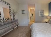 Thumbnail 6 of 36 - a bedroom with a bed and a dresser at Autumn Park Apartments, Charlotte, North Carolina