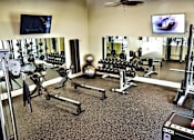 Thumbnail 18 of 25 - A gym with a variety of equipment including dumbbells, weight plates, and a bench press.at Carson Street Towers, Overland Park, 66223