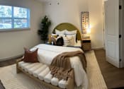 Thumbnail 8 of 9 - A bedroom with a bed, a window, a nightstand, and a rug.at Century Apartments, Memphis, TN  