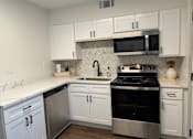 Thumbnail 9 of 9 - A kitchen with white cabinets and a black stove top oven.at Century Apartments, Memphis, 38117  