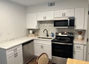 Thumbnail 2 of 9 - A kitchen with white cabinets and a black stove top oven.at Century Apartments, Memphis, 38117  