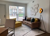Thumbnail 1 of 9 - A living room with a yellow chair and a brown couch.at Century Apartments, Memphis, TN  