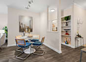 Thumbnail 12 of 42 - Dining area with round table and blue upholstered chairs at Alden Place at South Square Apartments, Durham, North Carolina