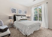 Thumbnail 13 of 42 - Bedroom with white bedding and large window at Alden Place at South Square Apartments, Durham, 27707