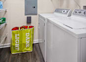 Thumbnail 16 of 42 - Laundry room with storage shelves and sorting hamper at Alden Place at South Square Apartments, Durham, 27707