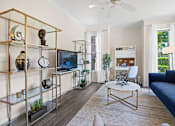 Thumbnail 3 of 42 - Living room with gold shelving and navy sofa at Alden Place at South Square Apartments, Durham, North Carolina