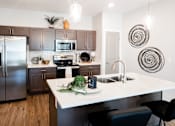 Thumbnail 2 of 22 - a kitchen with a large island and stainless steel appliances at City Place at Germantown Apartments, Memphis