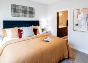 Thumbnail 4 of 17 - a bedroom with a large bed and a bathroom in the background