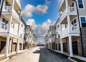 Thumbnail 6 of 17 - a street with rows of apartment buildings on each side
