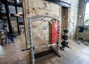 Thumbnail 16 of 23 - a gym with a brick wall and a red door in the background at Conwood Flats, Memphis, TN