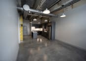Thumbnail 2 of 23 - a kitchen and dining area in a room with concrete floors at Conwood Flats, Memphis