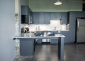 Thumbnail 3 of 23 - a kitchen with gray cabinets and stainless steel appliances at Conwood Flats, Memphis, Tennessee