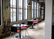 Thumbnail 11 of 23 - a row of tables and chairs in front of a wall of windows at Conwood Flats, Memphis