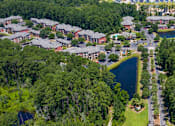 Thumbnail 26 of 29 - A bird's eye view of a residential area with houses, a pond, and a road.