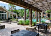 Thumbnail 19 of 29 - A patio with a table and chairs under a wooden pergola.